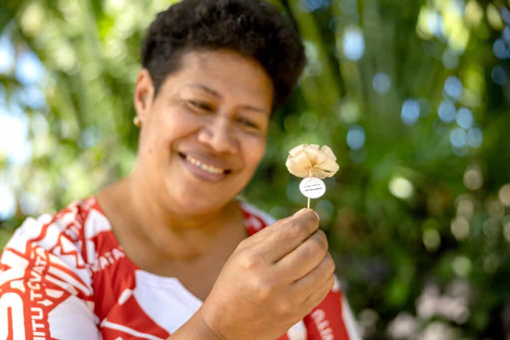 Woman in red and white dress holds a flower