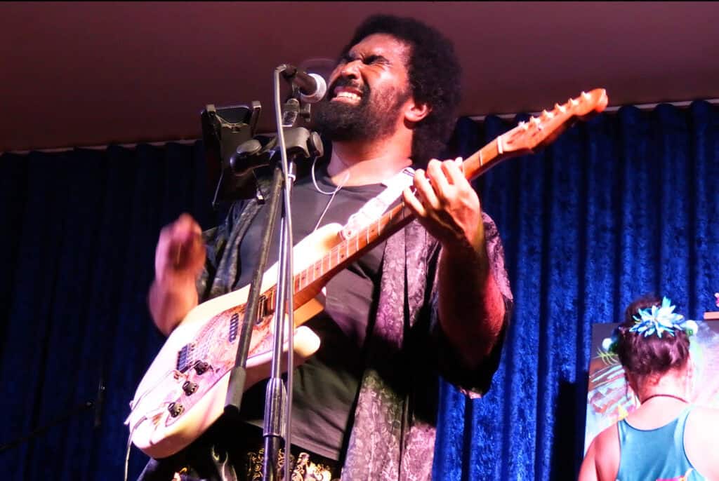 Man playing guitar with eyes closed