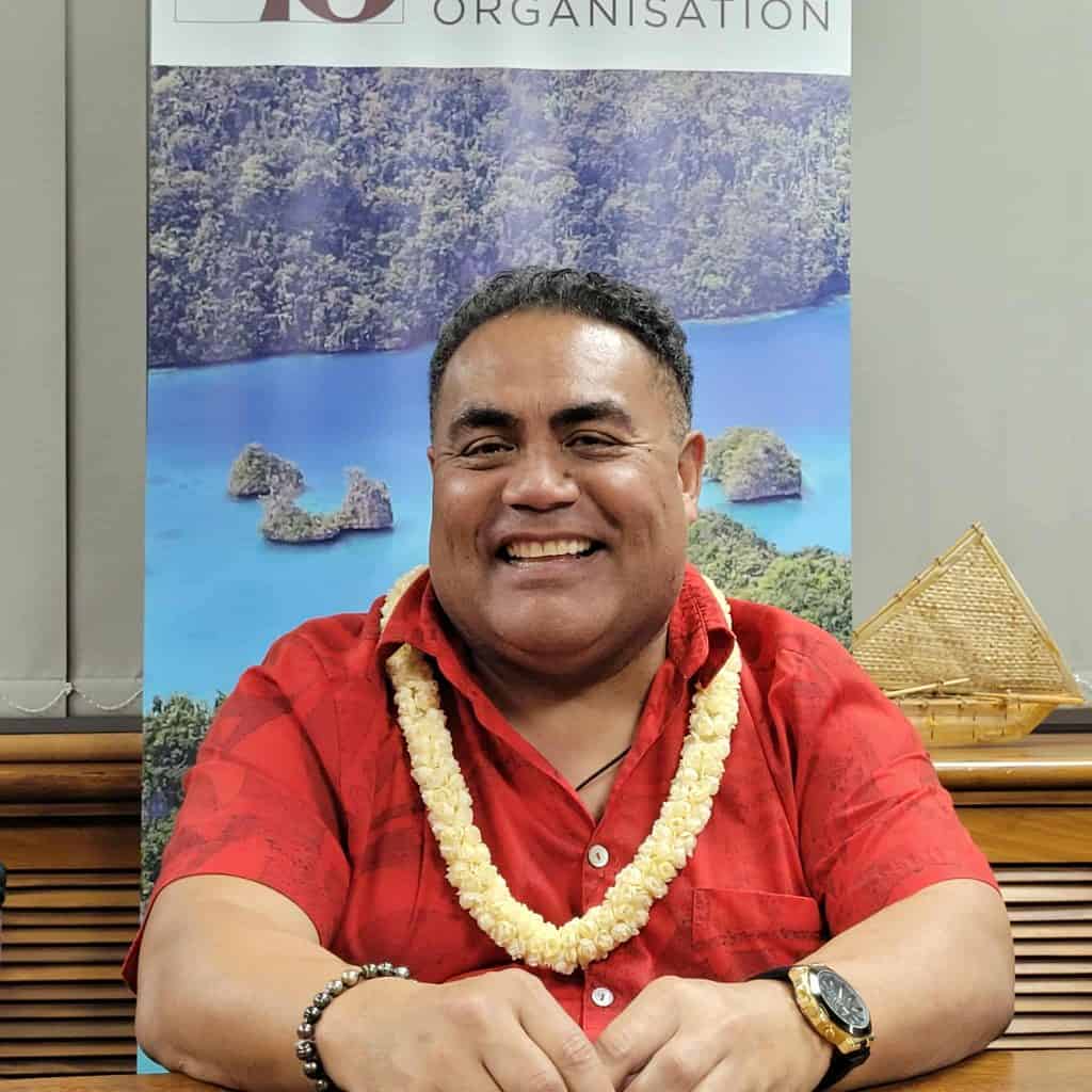 man in red shirt smiles at the camera